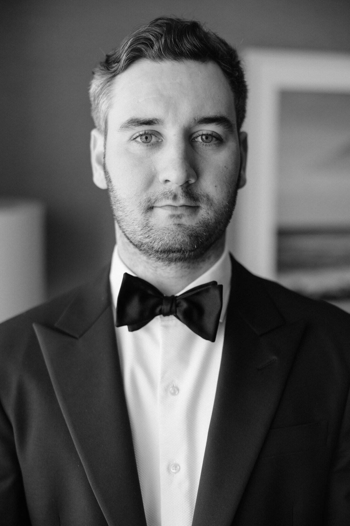 Groom wearing bowtie portrait in hotel room