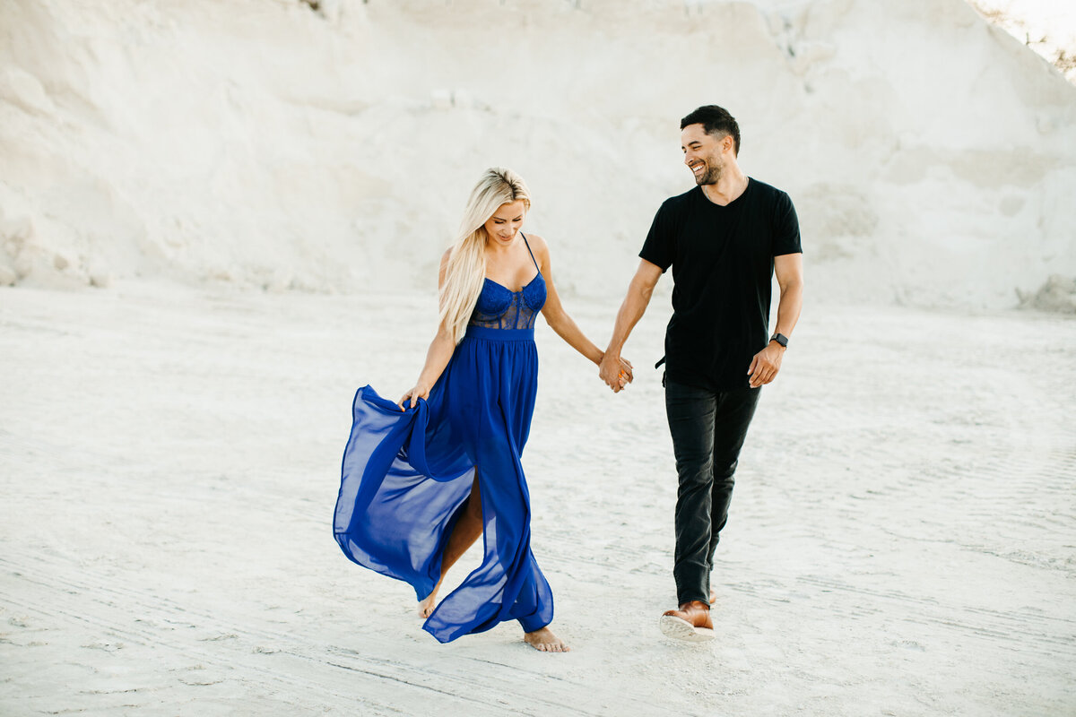 couple walking in the sand holding hands