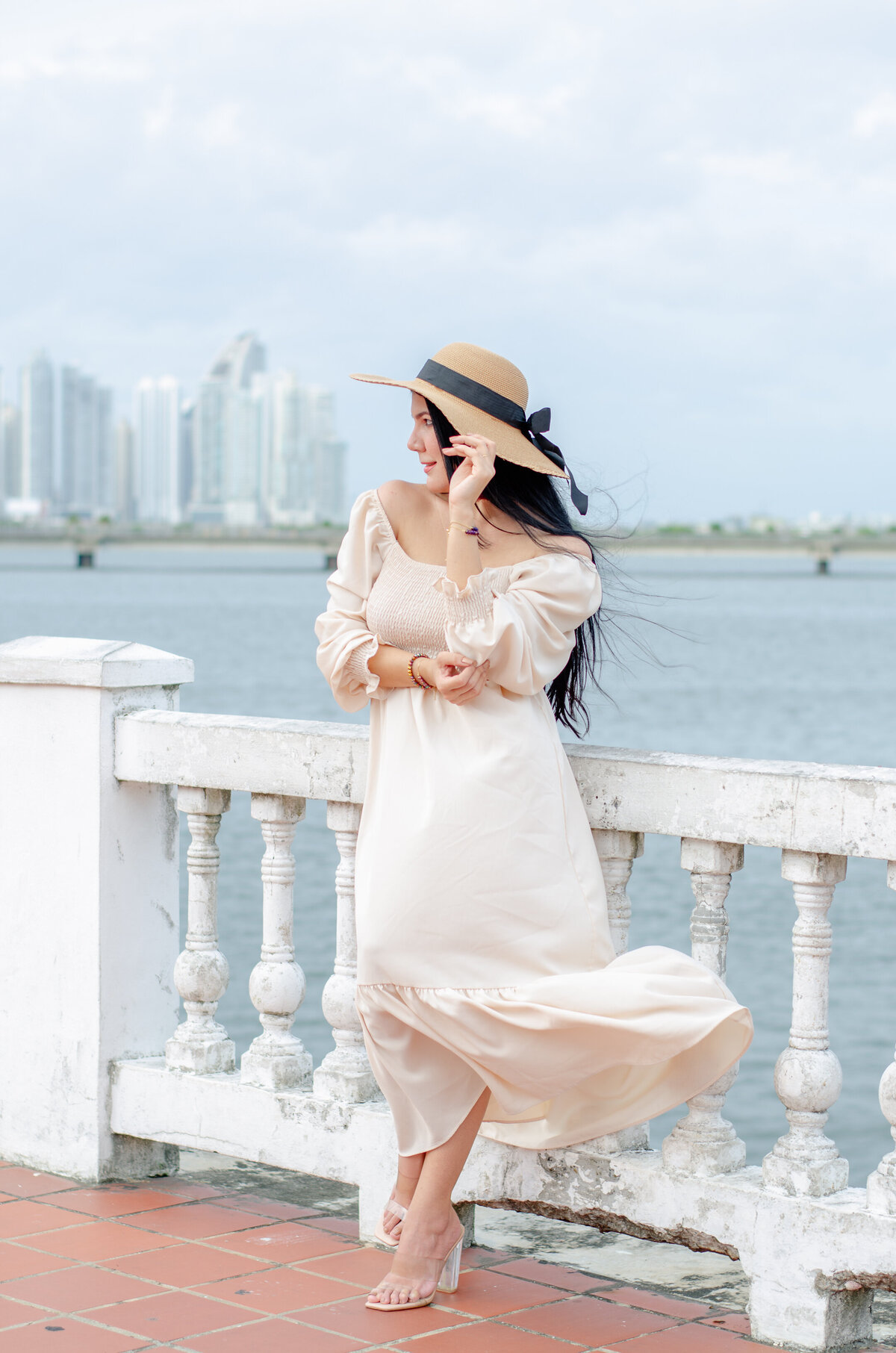 a woman leans against the railing overlooking the ocean in Casco Viejo, Panama