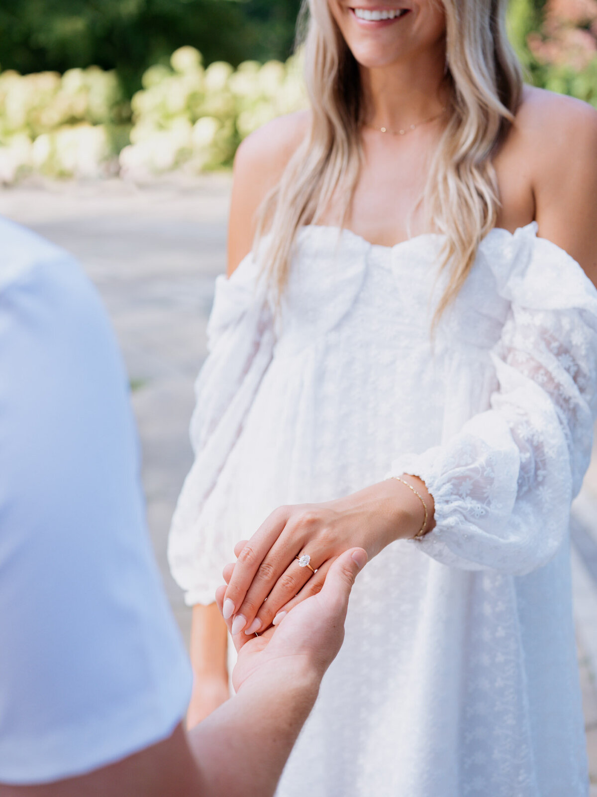 Groom holding bride's hand showcasing her engagement ring at the Cultural Gardens in Cleveland, OH.
