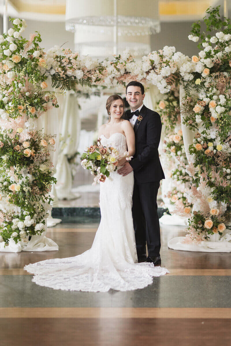 Bride and groom in front of florals by wedding planners chicago il
