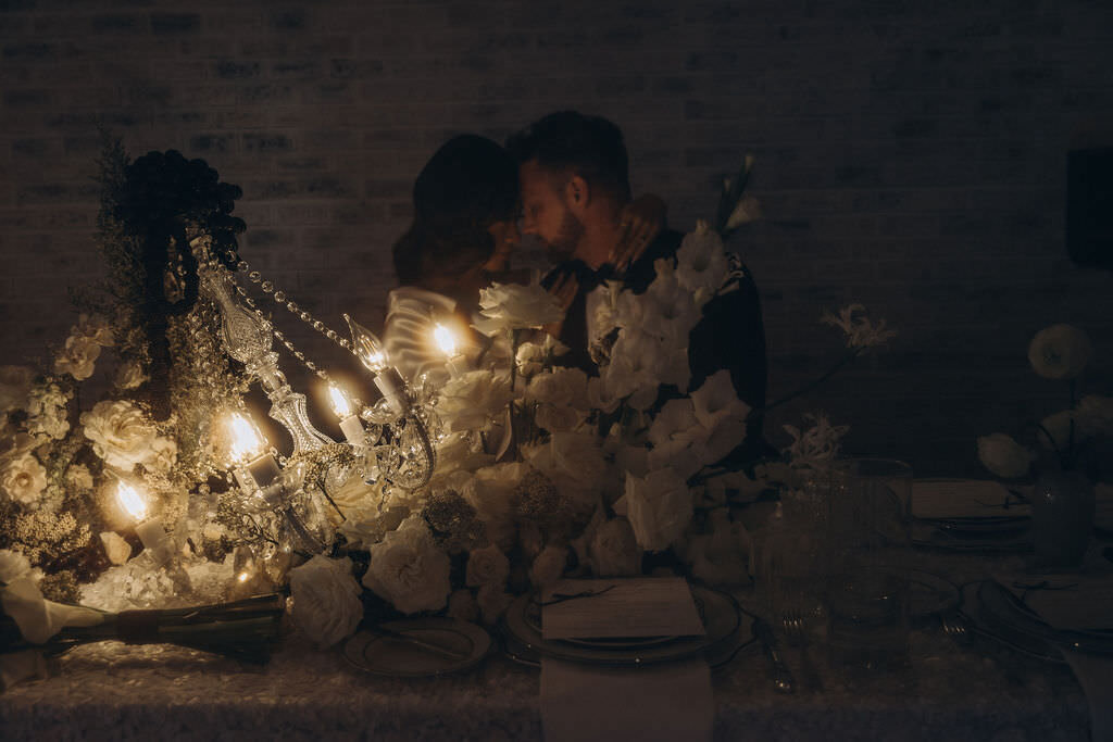 A couple with their foreheads together and soft light in front of them.