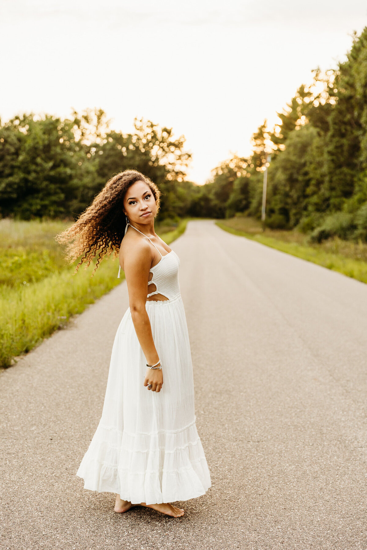 beautiful teen spinning in her dress in the middle of the road in Door County