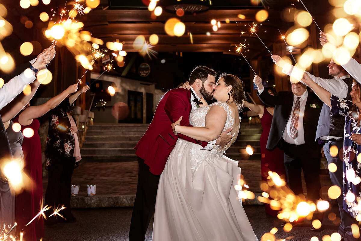 bride and groom kissing during sparkler exit at Pats Peak Wedding in Henniker NH
