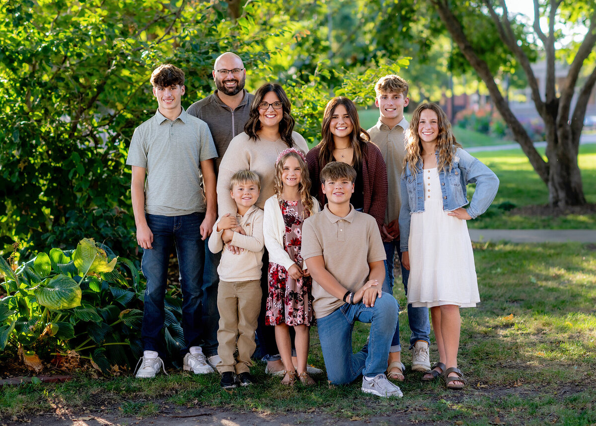 A happy family gathers in a garden to take photos together