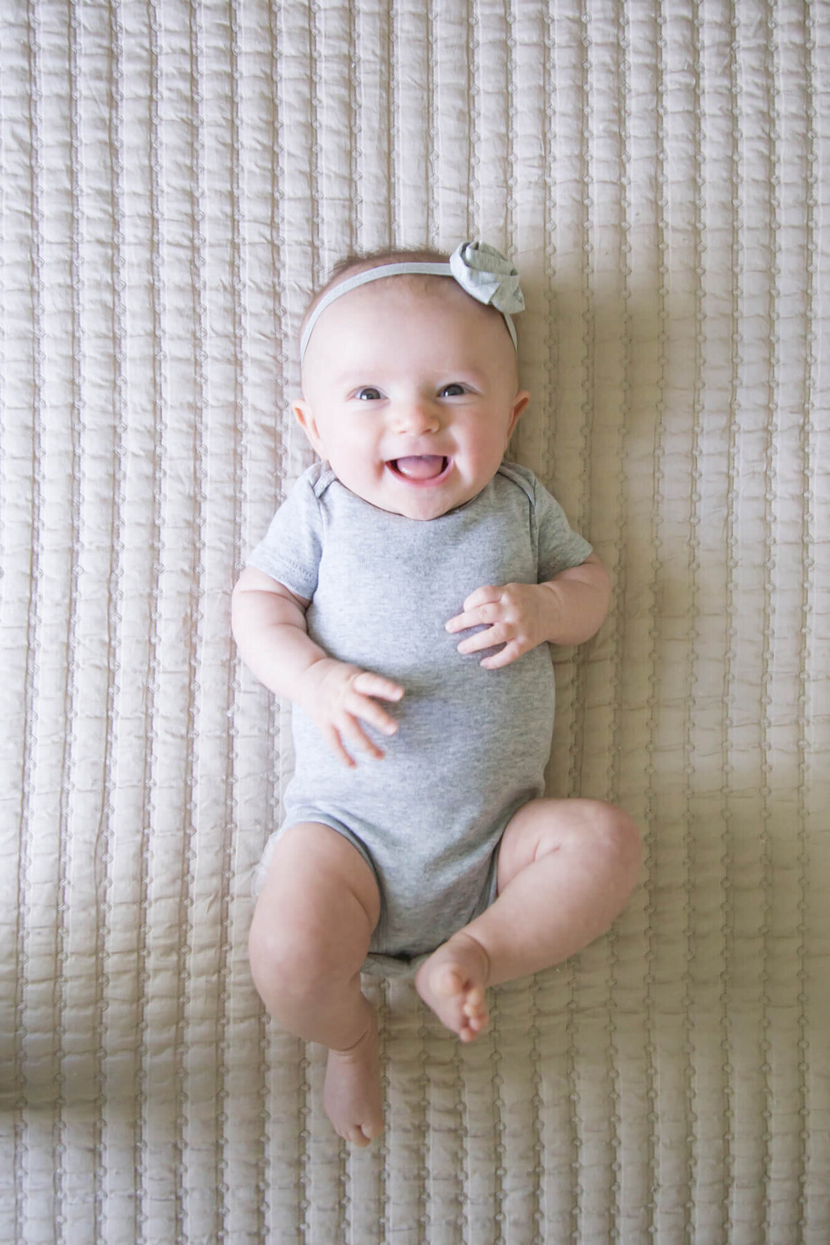 view from above of laughing baby girl  on a bed