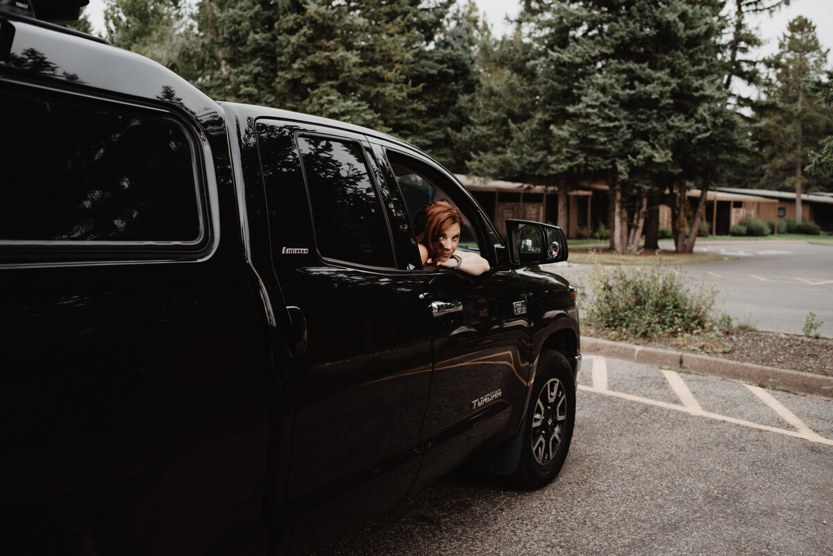 Jackson Hole photographers capture bride sitting in truck with head out window