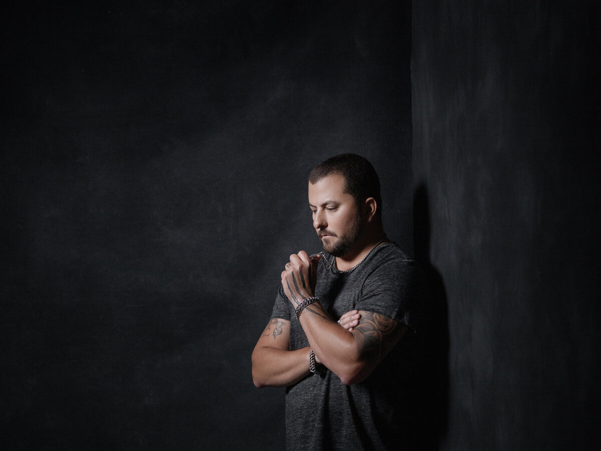 A man with his arms crossed in a corner