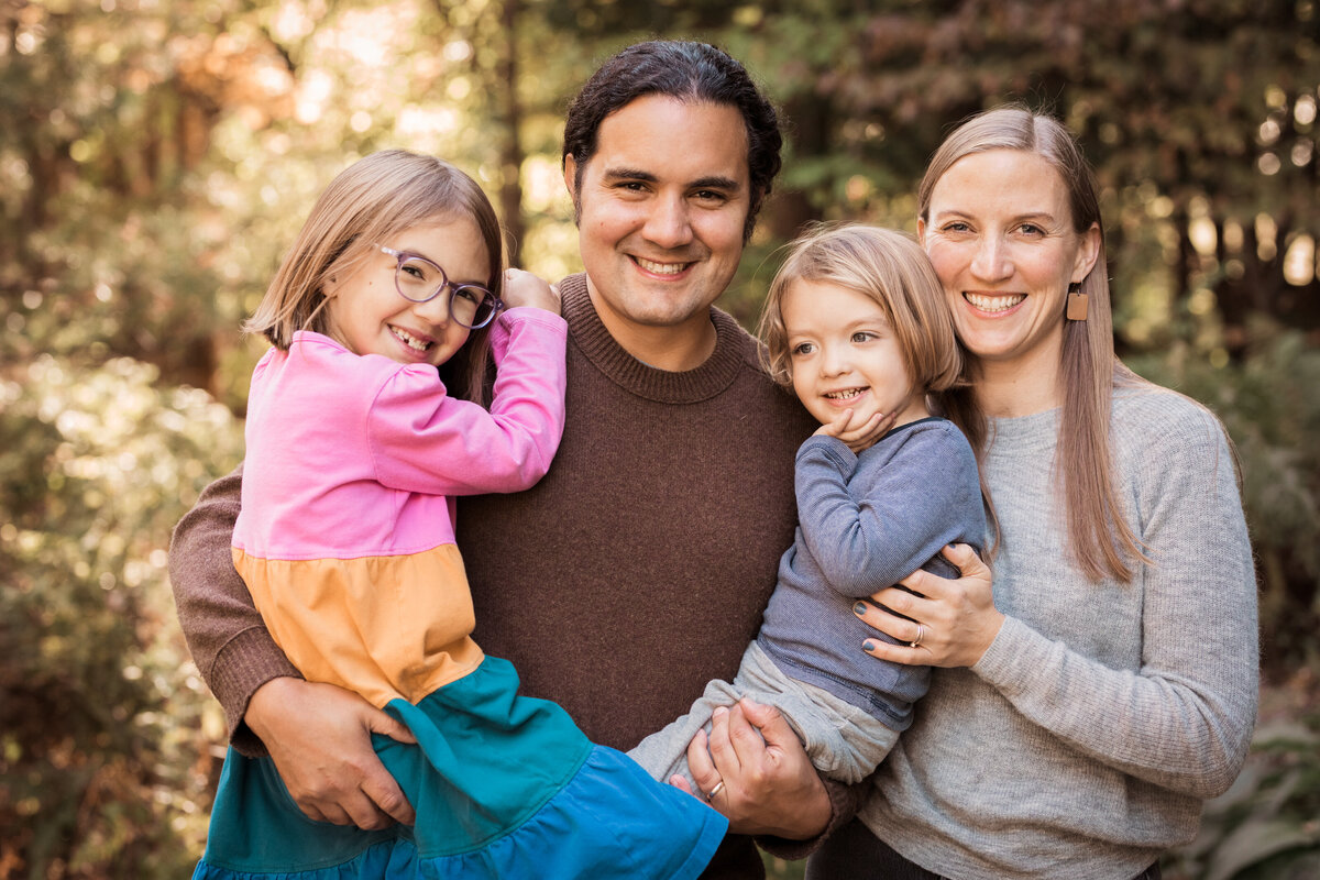mom and dad holding 2 kids outdoor fall session by Burlington Vermont Photographer