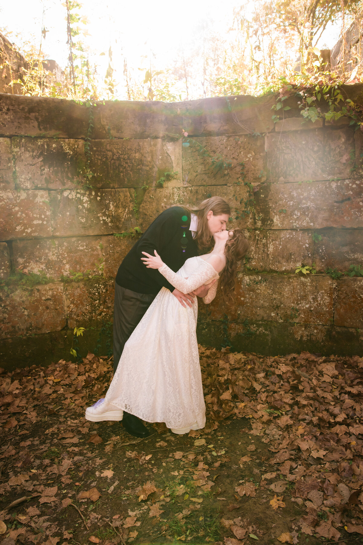 Couple kiss at Lock 29 park with sunflare behind them