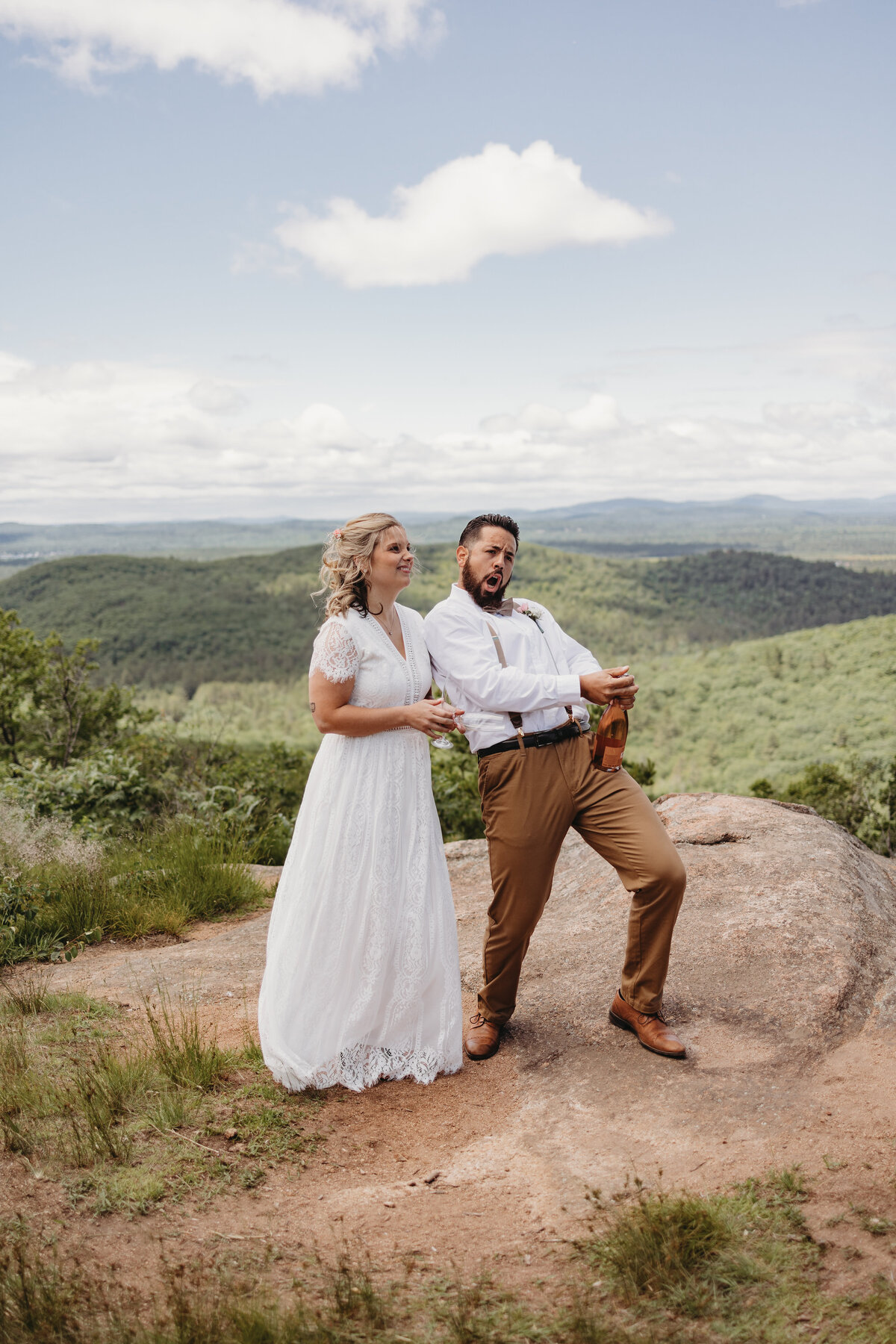 bride and groom posing on rock
