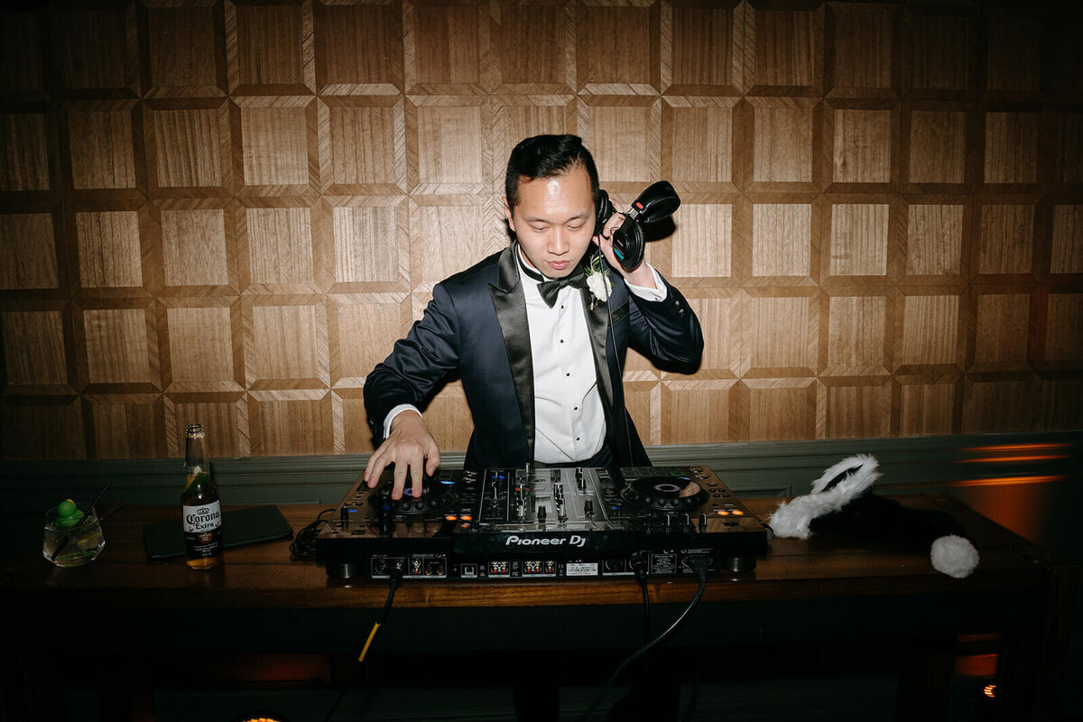 Groom DJing during the wedding reception at St. Regis Aspen, entertaining guests with music in a lively celebration atmosphere.