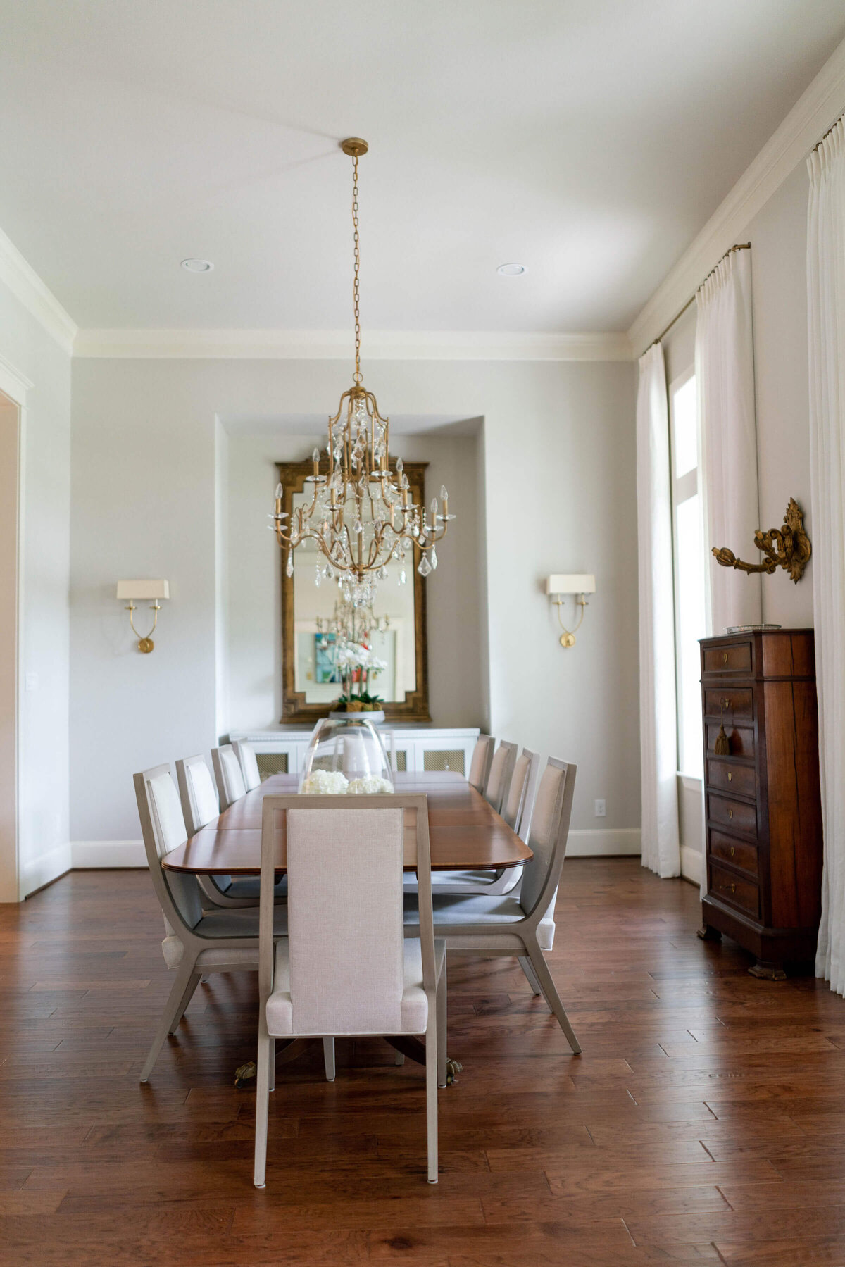 oyster creek studios heathcott tan chairs and crystal chandelier around dining room table