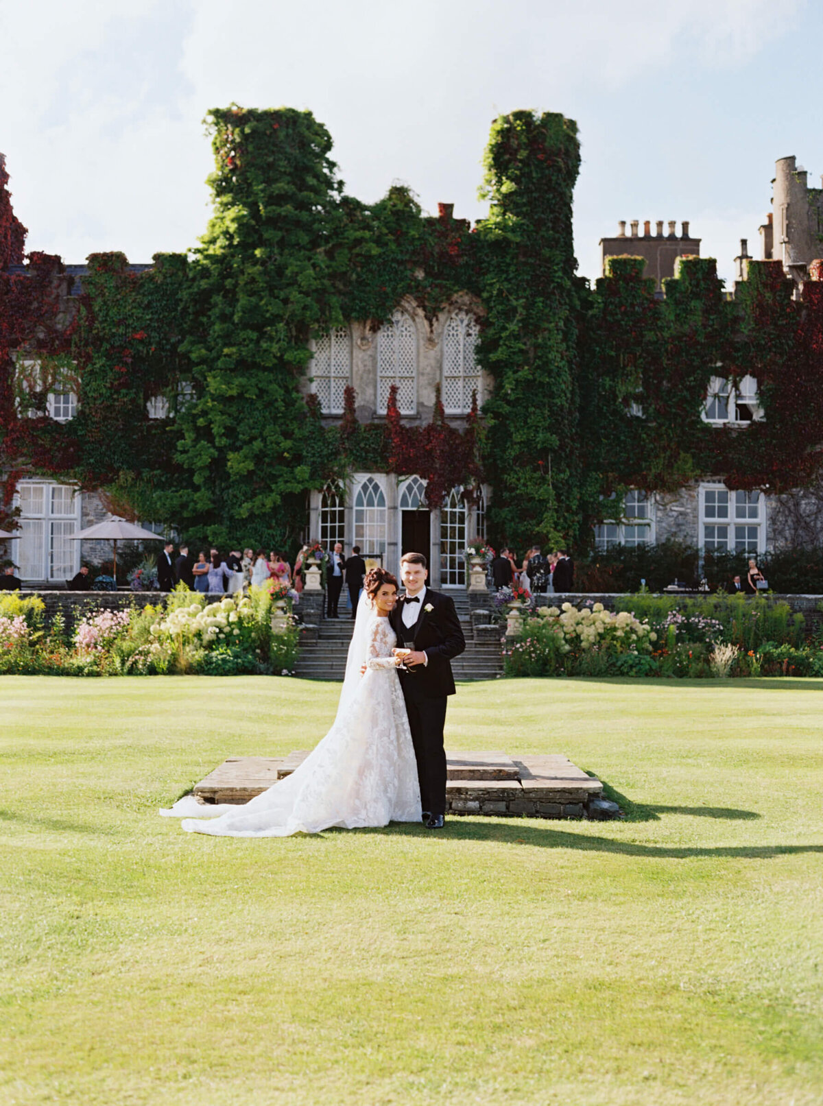 A wedding photo of the bride and groom together with Luttrellstown Castle behind them