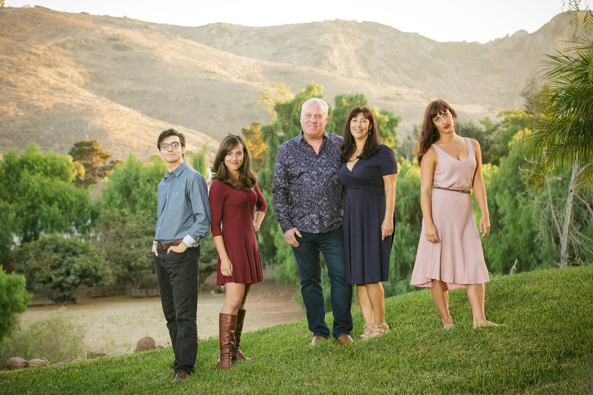 A family standing on a hill together smiling