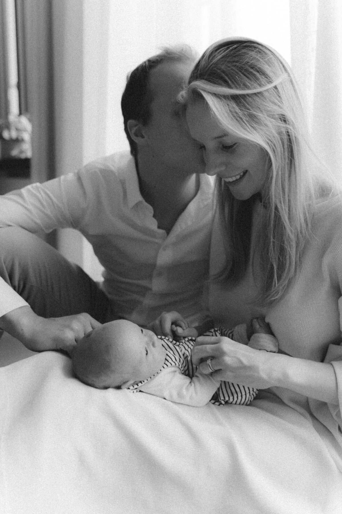 Moeder en vader knuffelen baby op de schoot.