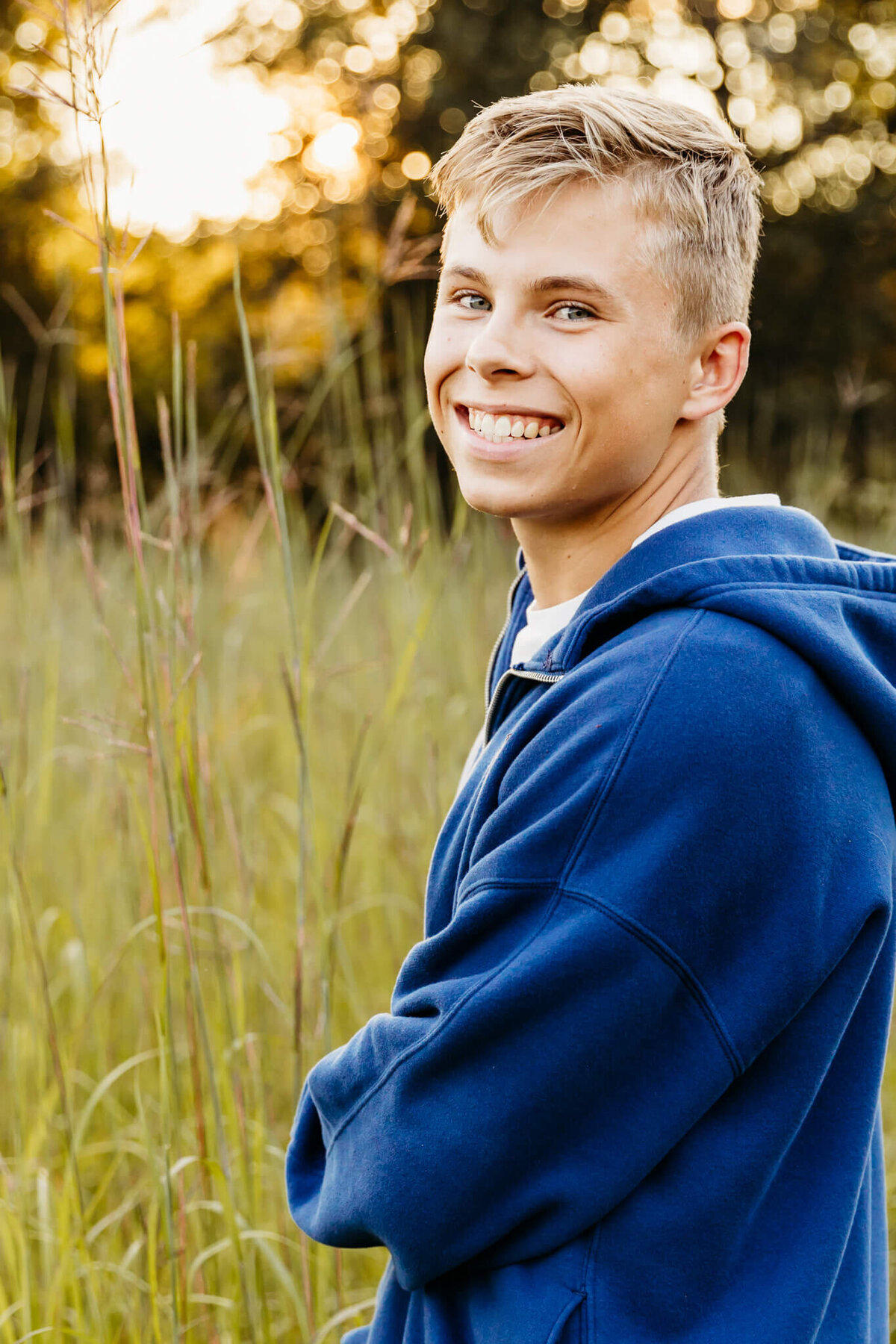 blonde teen boy looking over his shoulder smiling