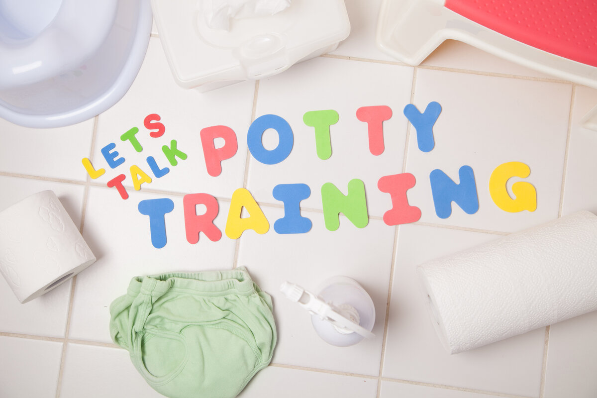 Colorful letters spelling, "Let's Talk Potty Training" assembled on a title bathroom floor