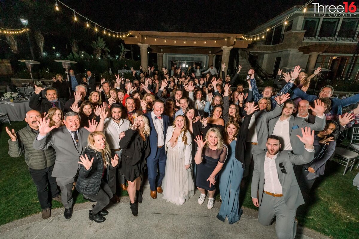 Group of wedding guests squeeze in for a group photo