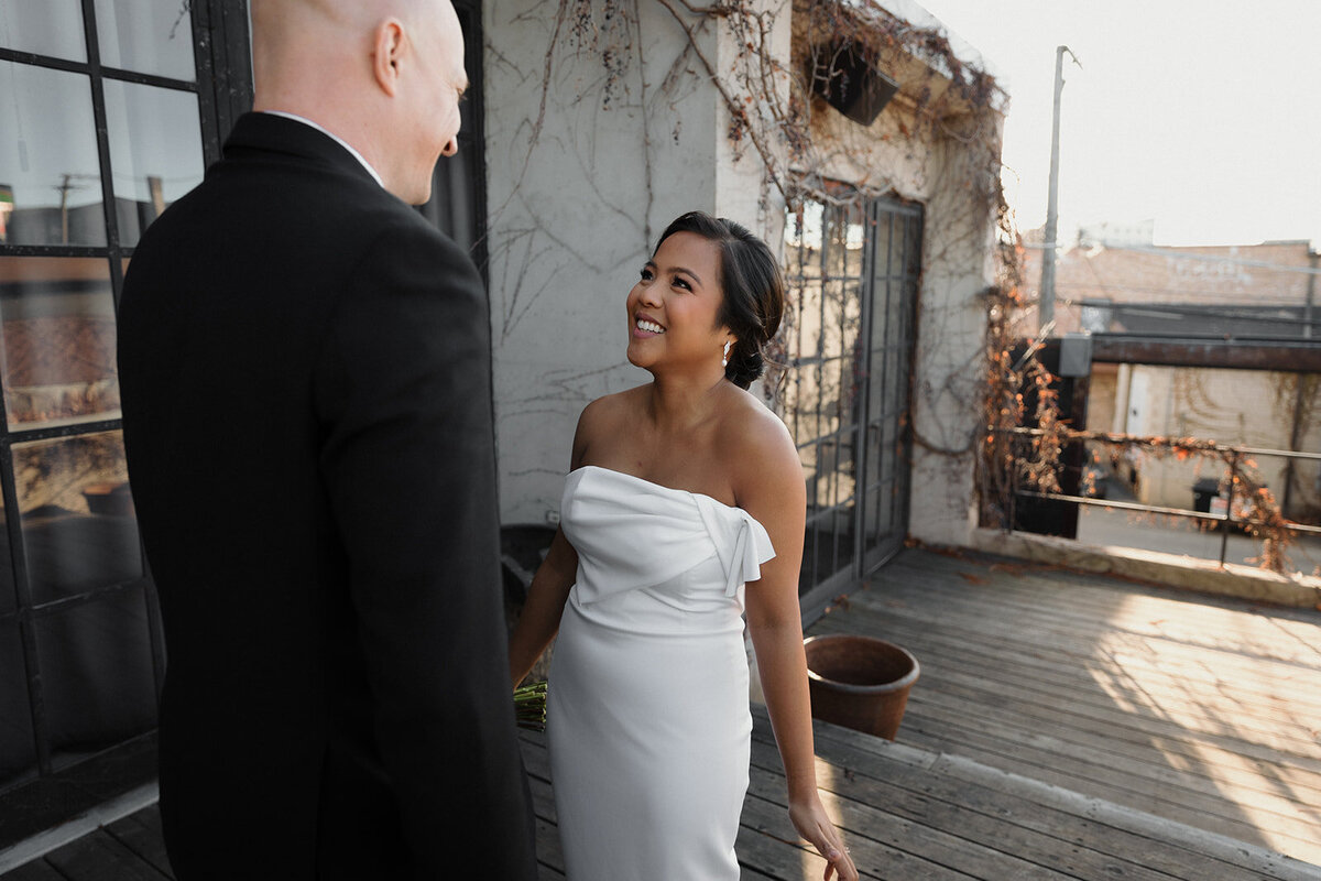 bride is beaming as groom turns to look at her for first look