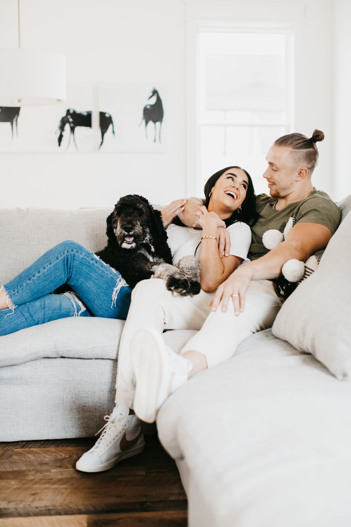 couple holding each other on a couch with dog in home