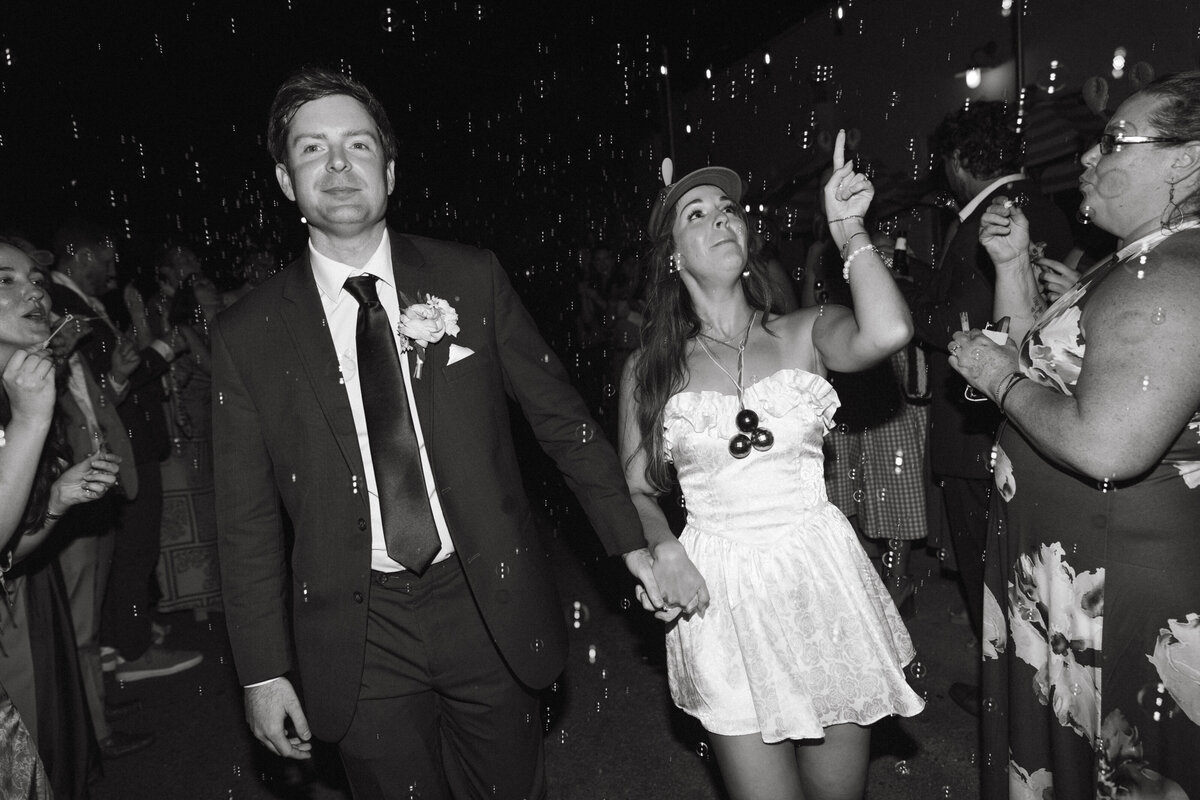 Bride and Groom walking through aisles of guests blowing bubbles