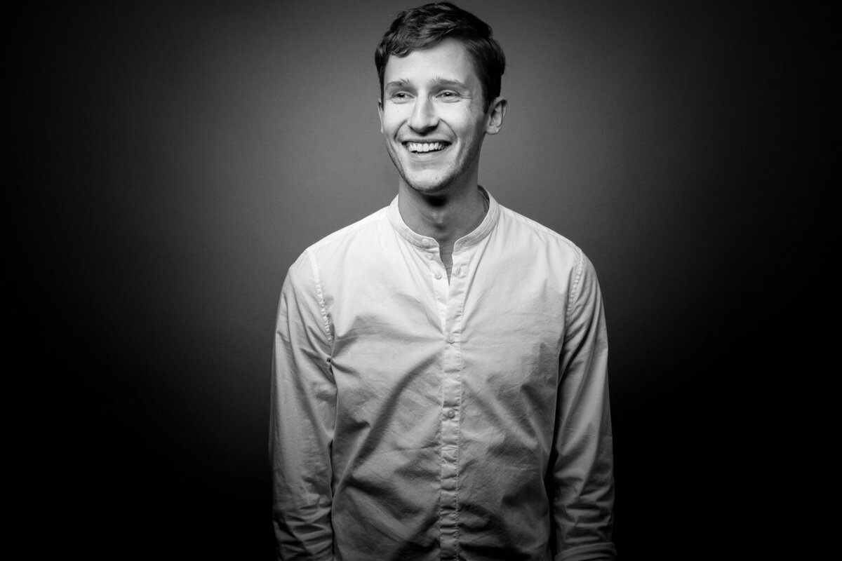 Studio headshot session showcasing clean, modern portrait styling on grey background.