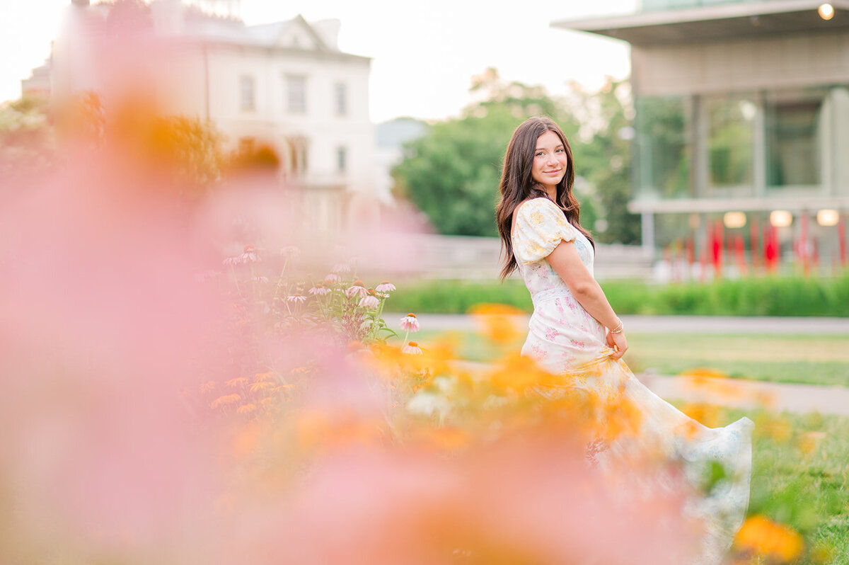 a girl posing next to a flower garden