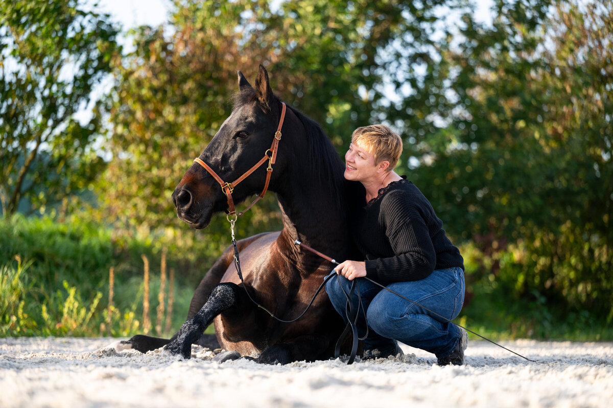 Pferdebild-liegendes-Pferd-mit-Mensch-Pferdefotografie-Mannheim