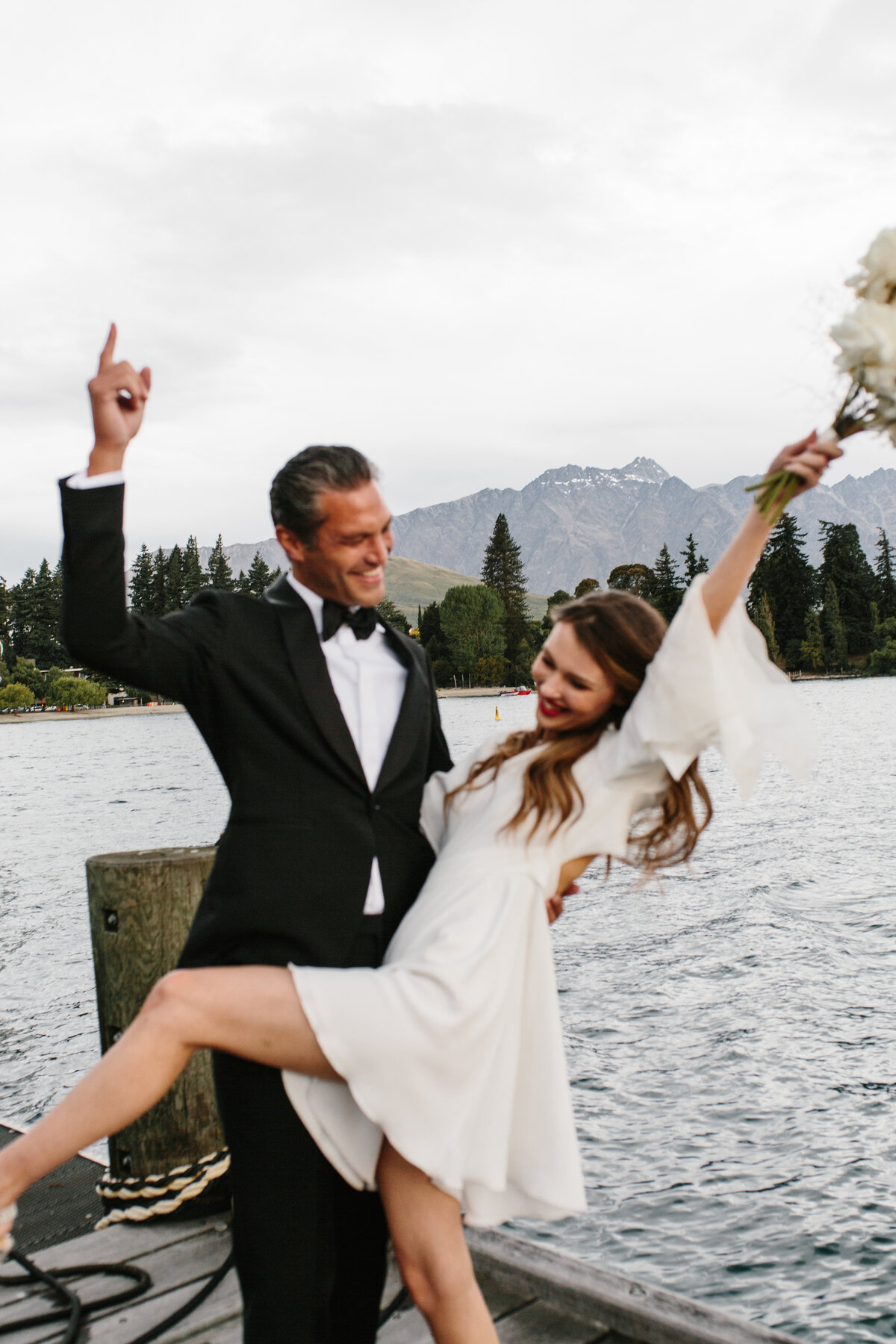 The Lovers Elopement Co - bride and groom celebrate after wedding on lakefront