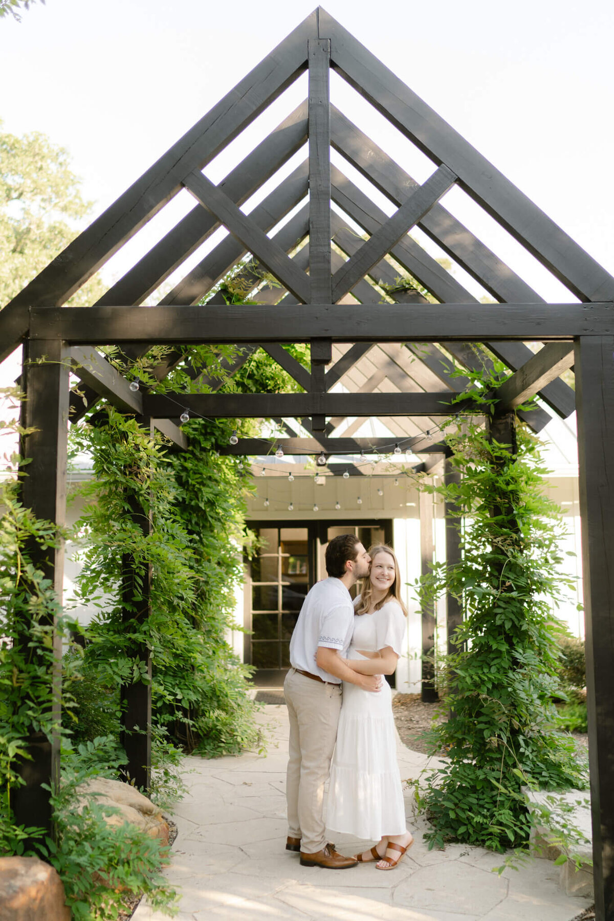 couple under a greenery arbor on a spring day