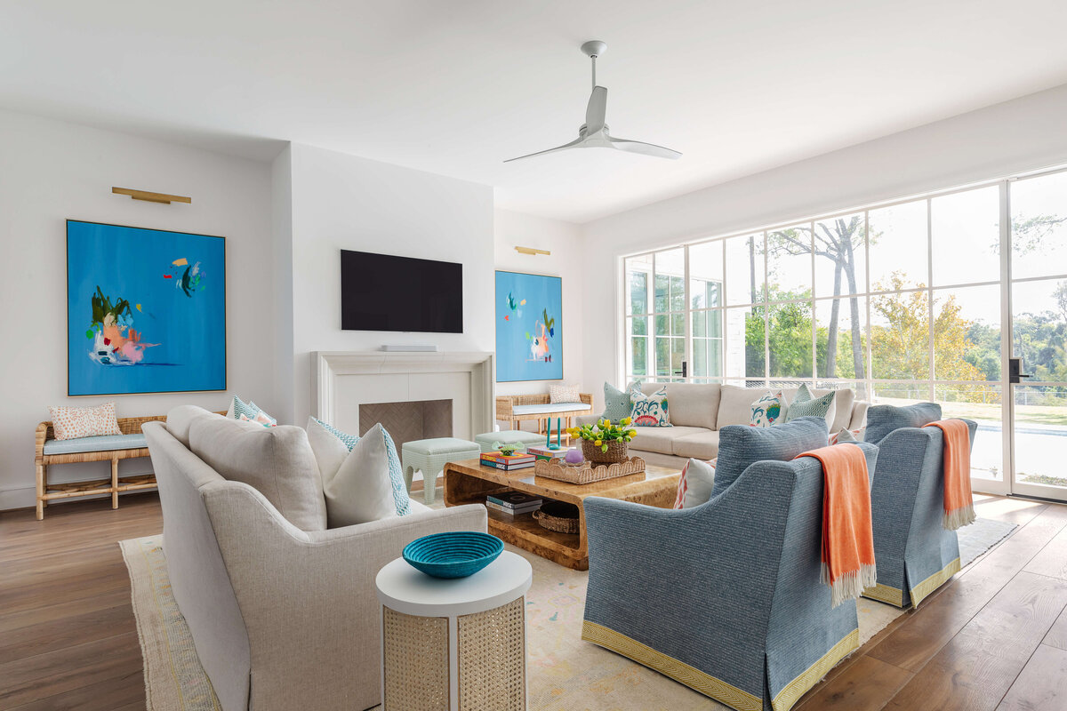 oyster creek studios memorial new build blue armchairs with orange blankets in living room with wooden coffee table white couch and fireplace