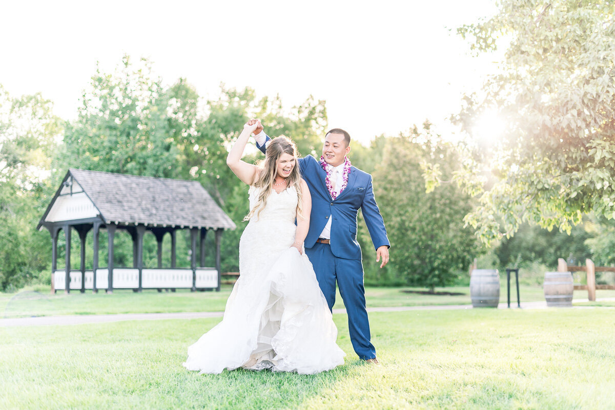happy couple dancing in a field of grass at the chatfield botanical garden perfect if you're looking for a wedding photographer in Colorado