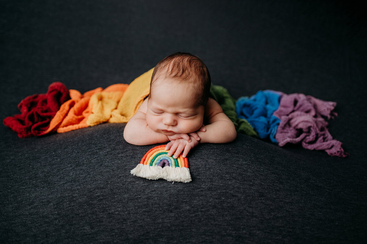 Baby  holding rainbow wrapped  covered in a rainbow wrap