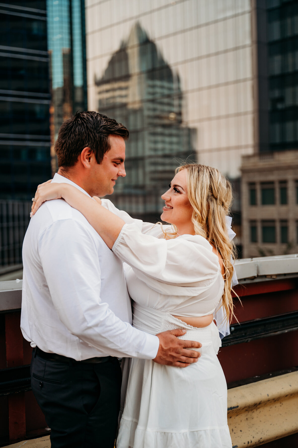 engaged couple looks at each other and smiles
