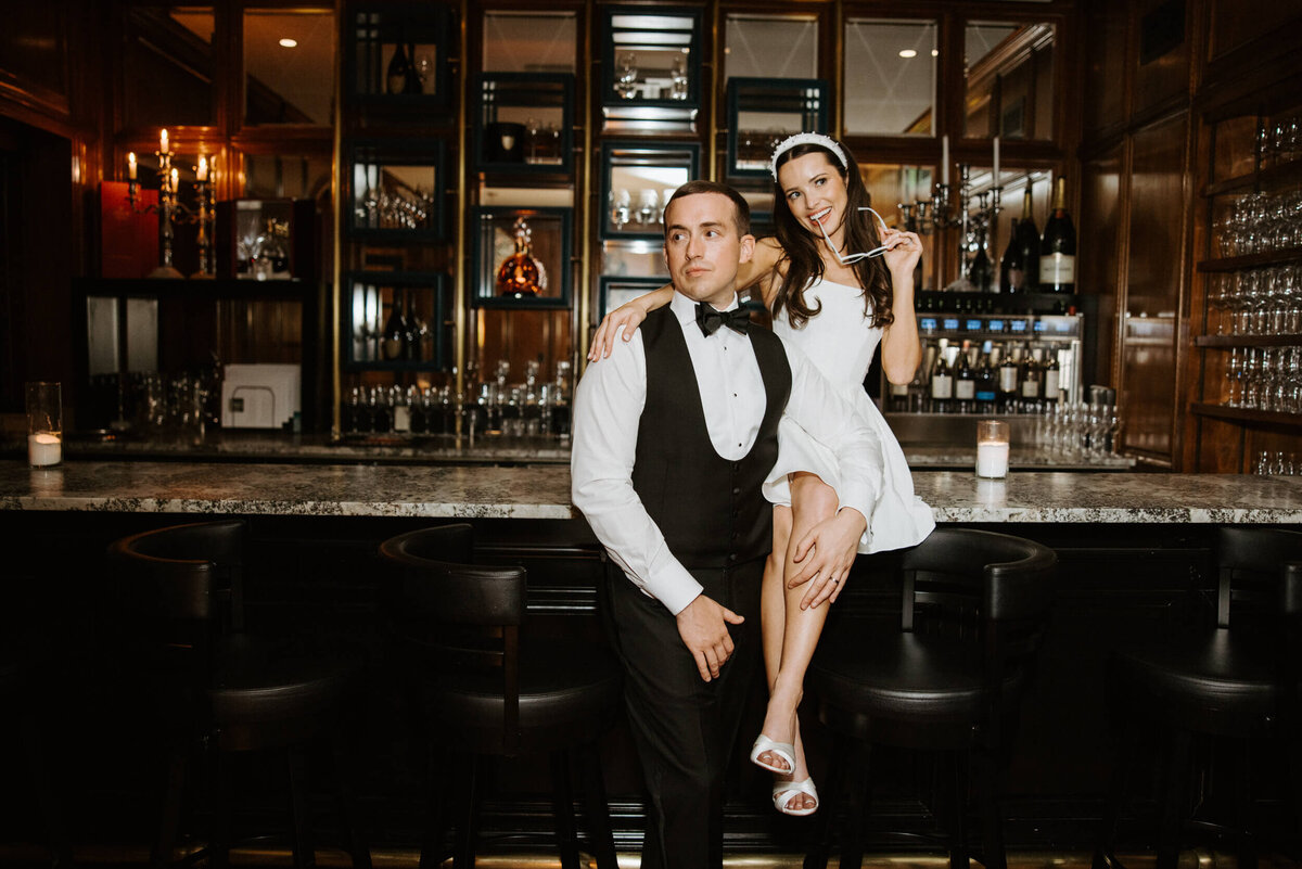 Bride and groom sitting by the bar in their stylish wedding planned by Black Tie Optional, Arizona