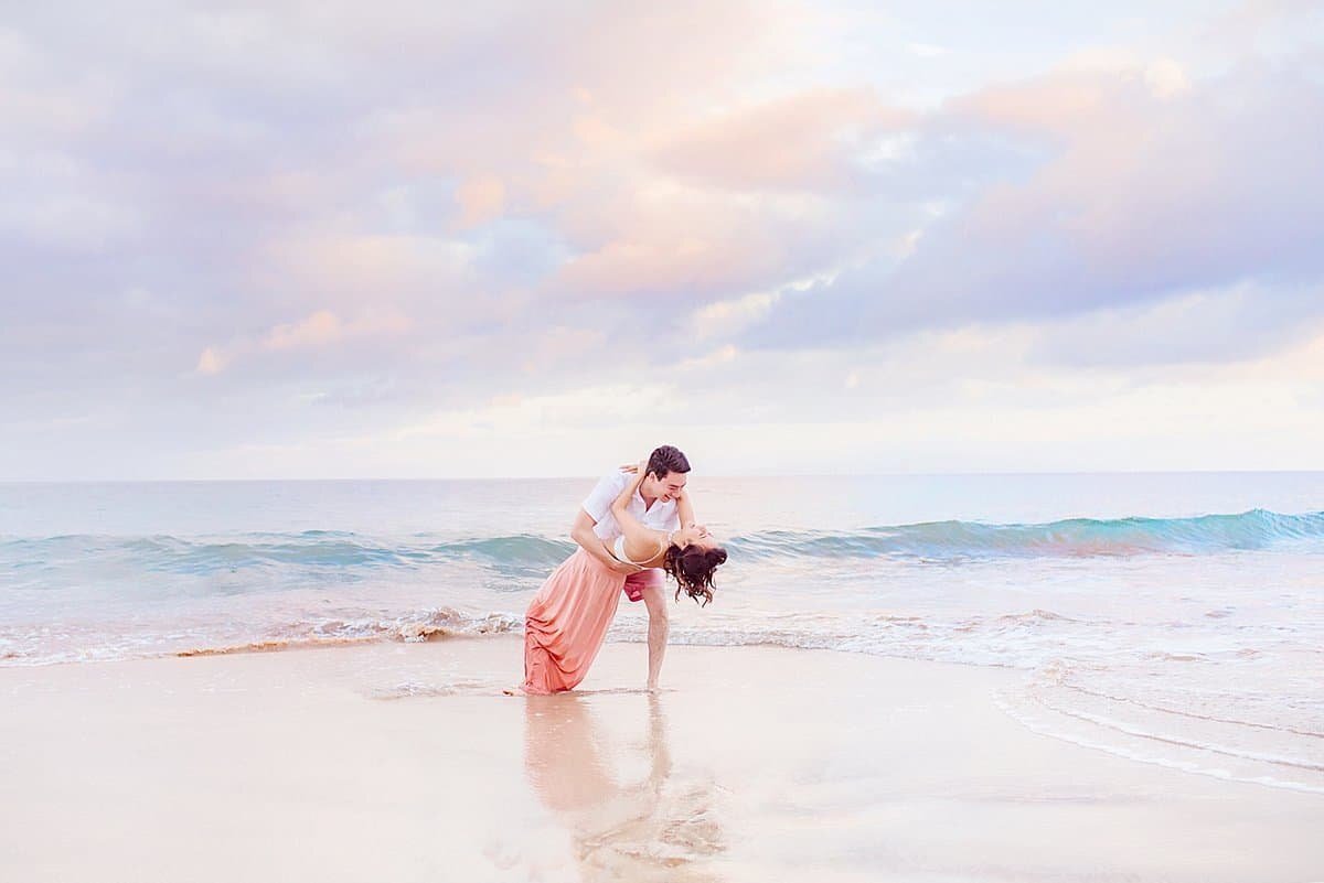 Husband dips his wife after proposing on the beach in Wailea, Maui