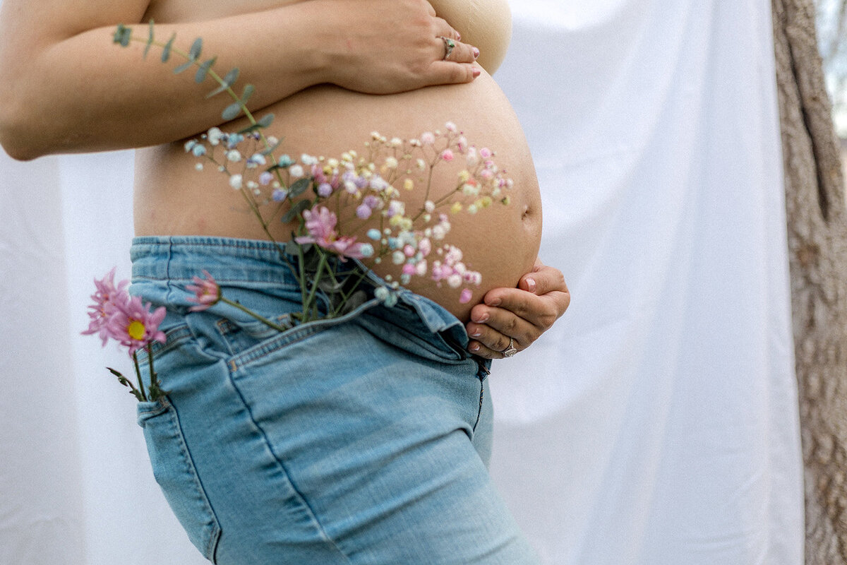 Close up of flowers near a pregnant belly