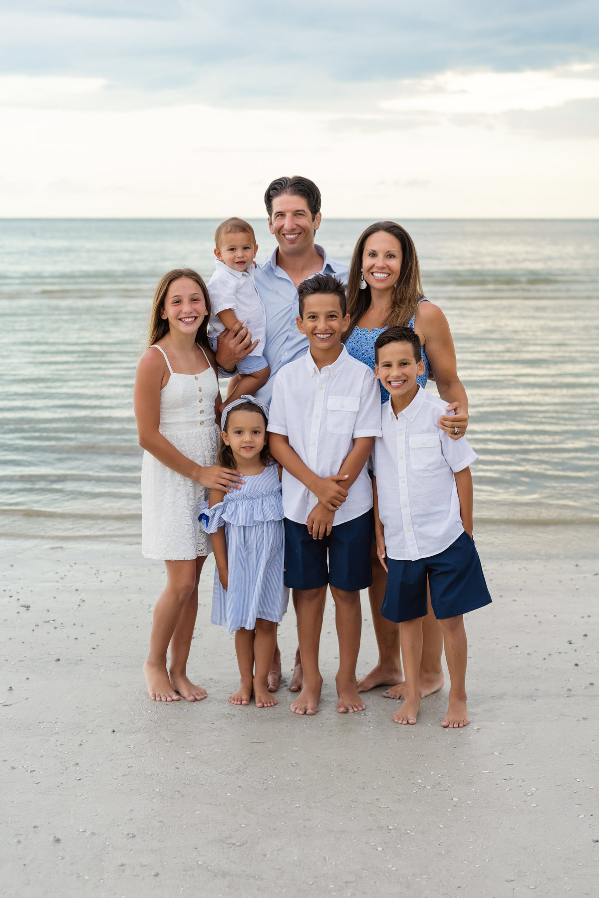 large family pose for a family photo together on Fort Myers Beach Florida