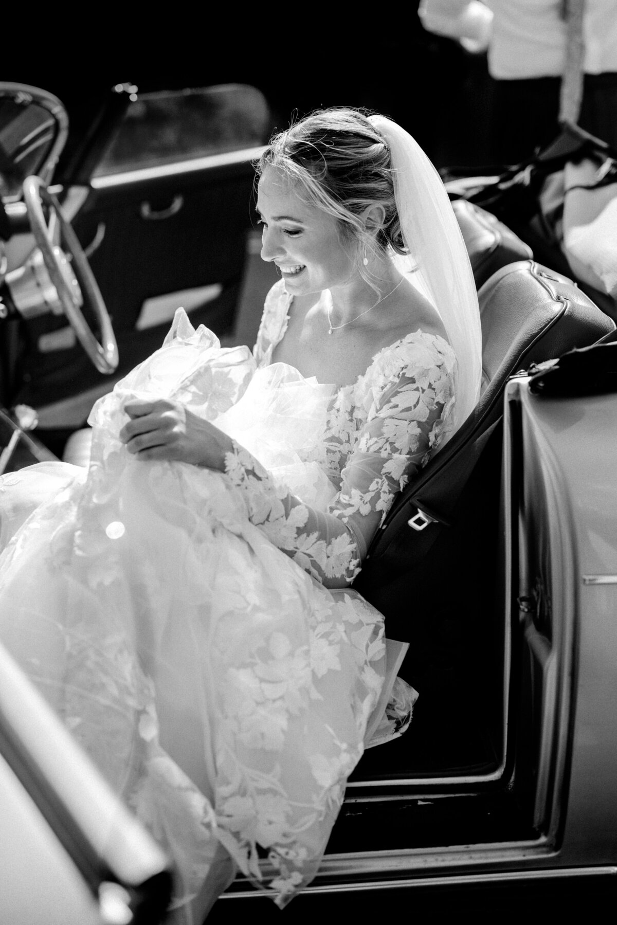 Bride gets out of her vintage wedding car on her wedding day