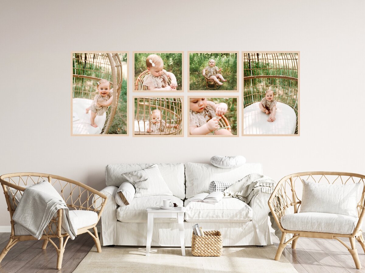 A cozy living room corner featuring a white sofa adorned with decorative pillows, flanked by two wicker armchairs, a small coffee table, and a wall decorated with a series of framed photographs capturing candid moments of a baby in a light and airy aesthetic.