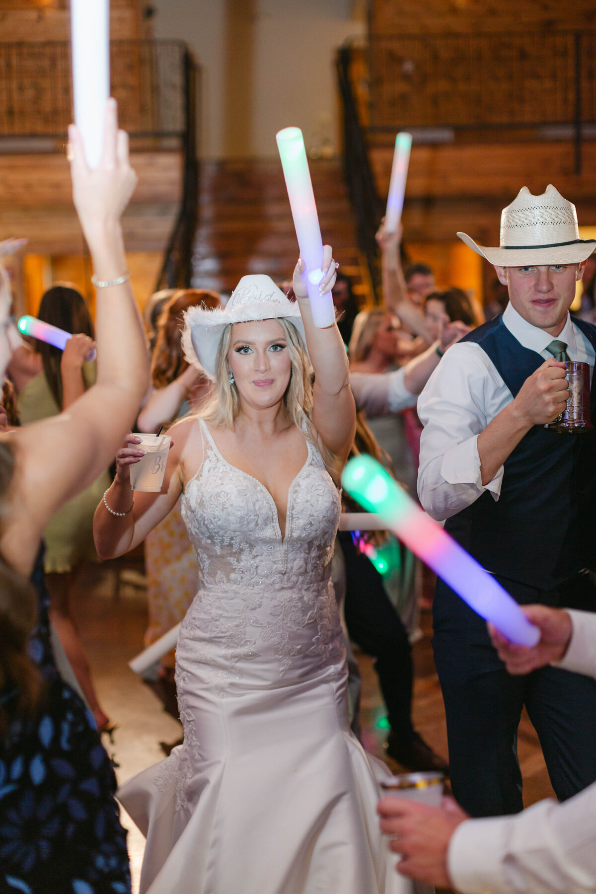 bride dancing with cowgirl hat