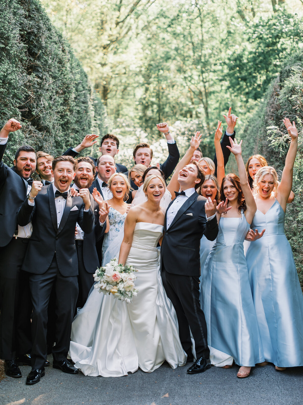 Wedding party cheering with bride and groom at Old Edwards Inn in Highlands, North Carolina, bridesmaids in soft blue dresses.