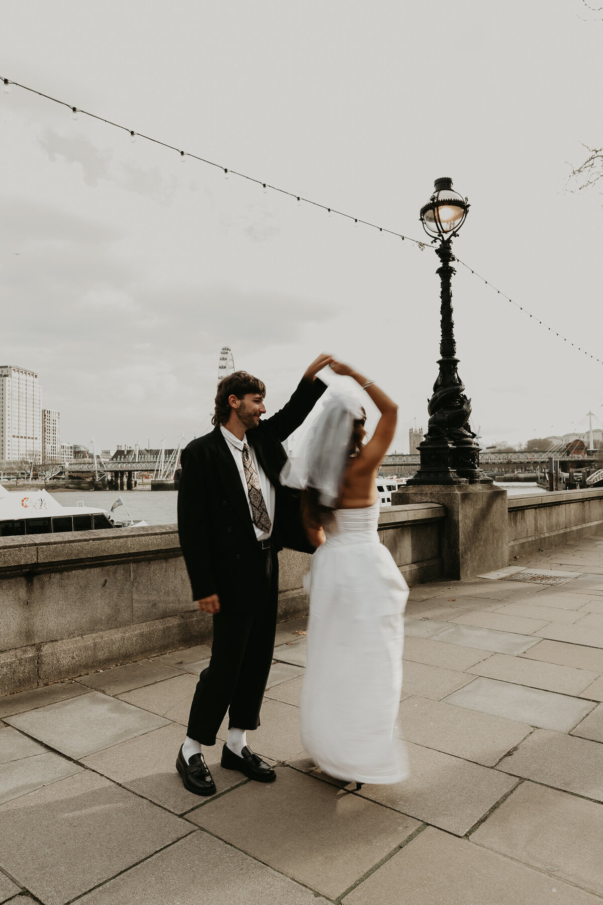 A couple dance on the river Thames on their wedding day.