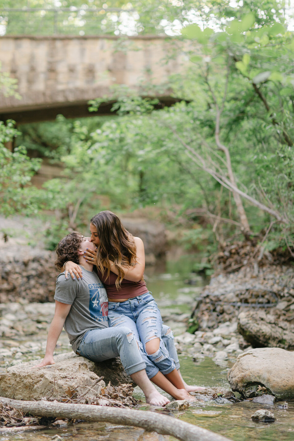 engaged couple kissing by river
