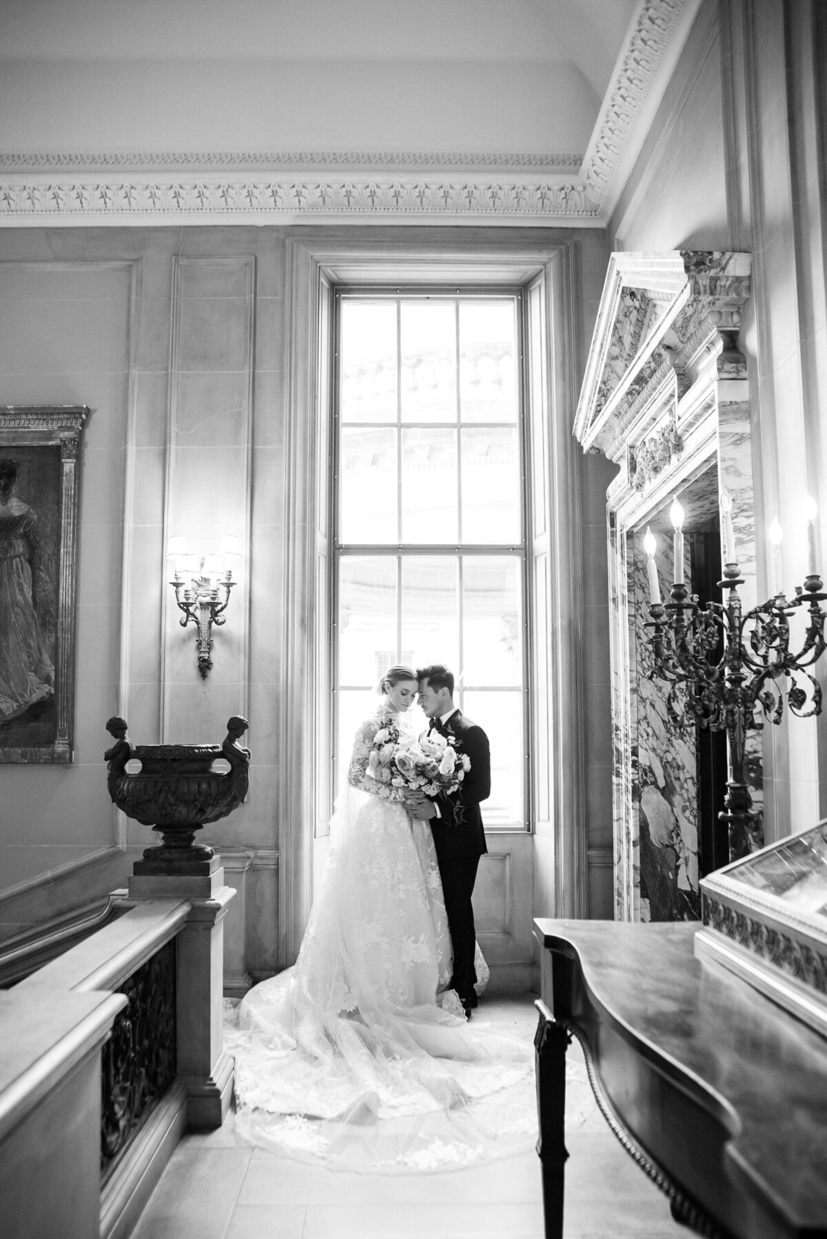 black and white picture of bride and groom together in front of a window