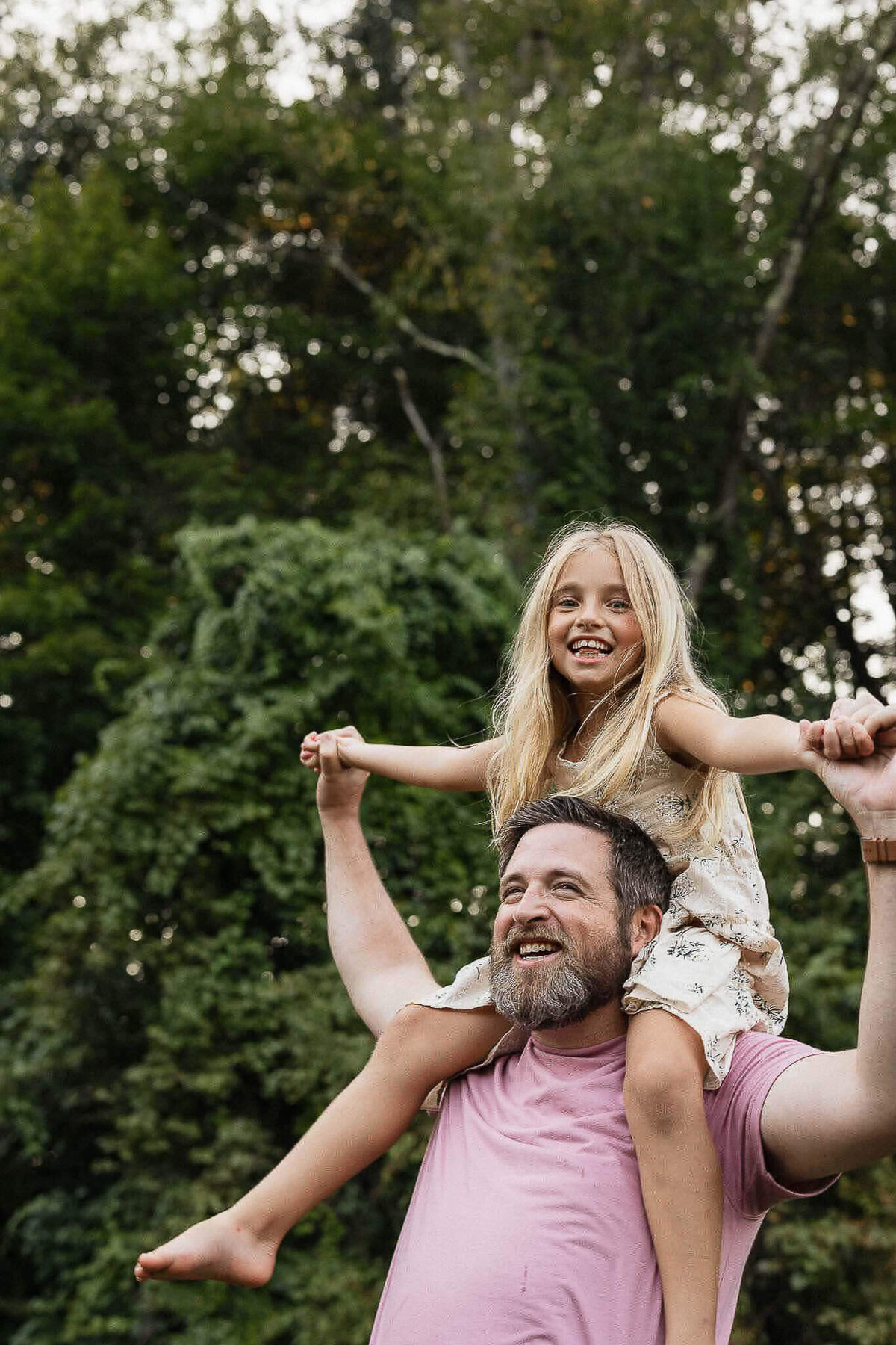 Daughter playfully riding on dad's shoulders during fall family photography session in Cleveland.