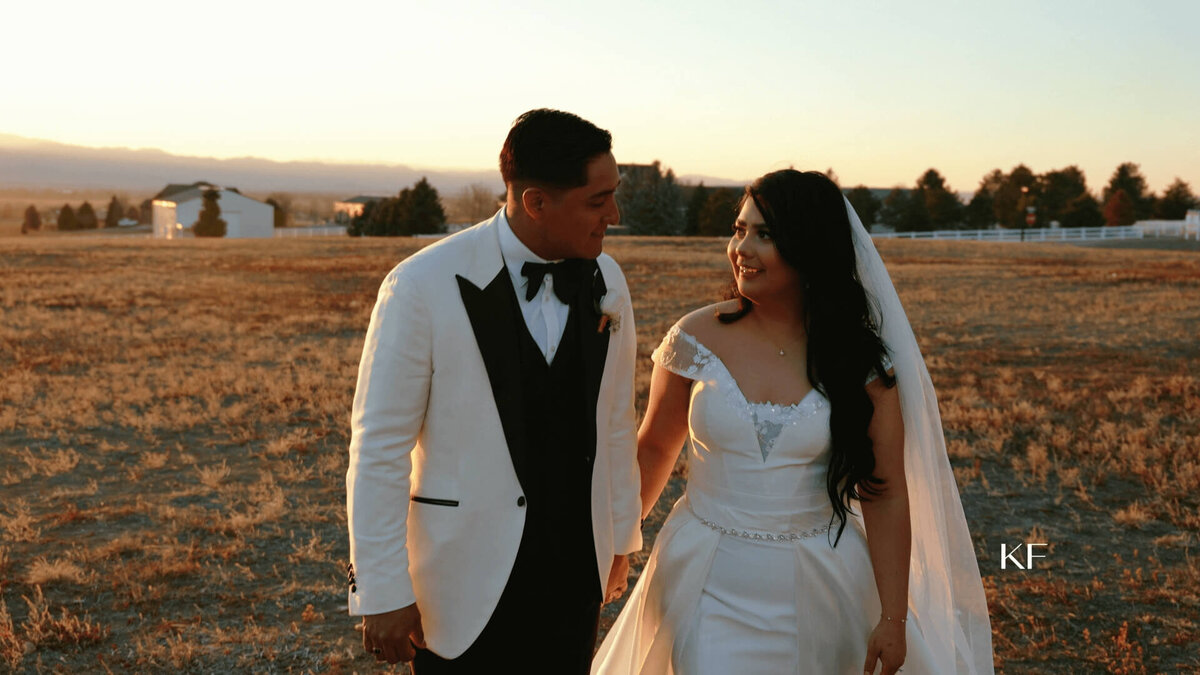 bride and groom walking outdoors with mountains in the background