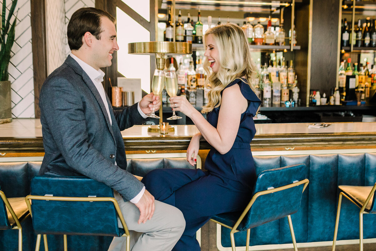 A couple sit at a bar in Lincoln Park while taking engagement photos