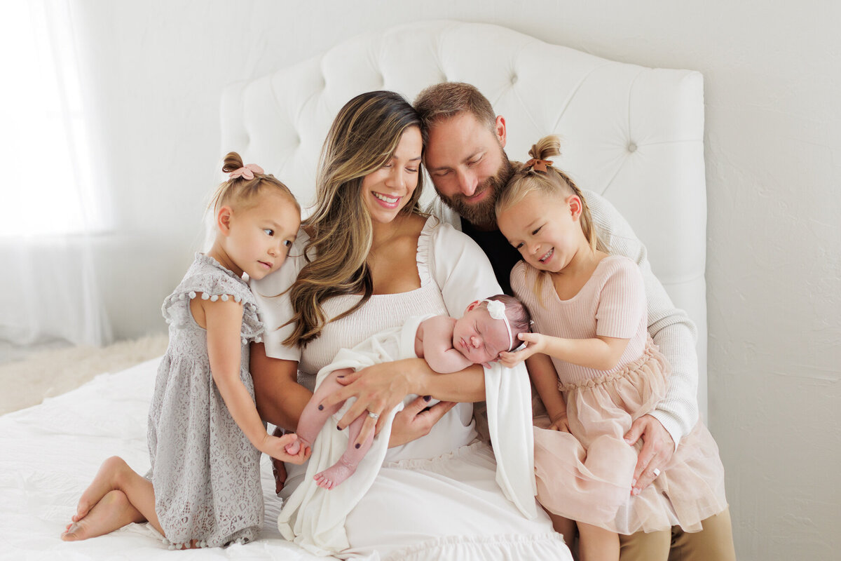 Family of 5 cuddled together during newborn portraits in Boise.